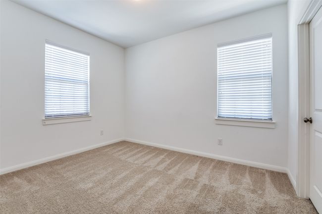 Second Bedroom - Bright and airy bedroom featuring soft, light-colored carpeting for a cozy feel, complemented by crisp baseboards that add a touch of elegance. The neutral palette offers a blank canvas, ready to be personalized to suit any style or need. | Image 27