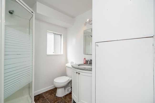 Full bathroom featuring baseboards, a shower stall, toilet, and vanity | Image 35