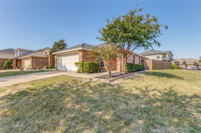 Corner property: Single story home featuring a front lawn and a garage | Image 1