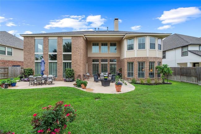 Backyard offers lush lawn for kids and pets to play and enough patio for two sitting areas. | Image 43