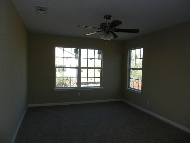 Empty room featuring ceiling fan and dark carpet | Image 18