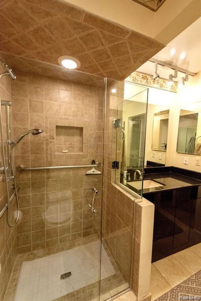 Bathroom featuring a stall shower, vanity, light tile patterned flooring, and recessed lighting | Image 25