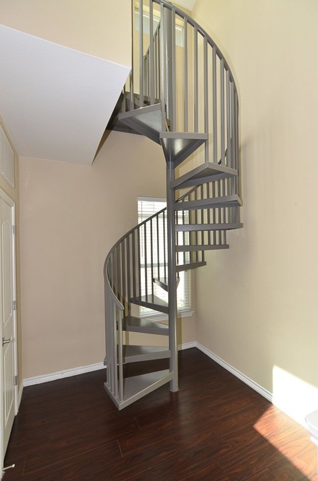 Spiral stairs lead to the rooftop patio | Image 18