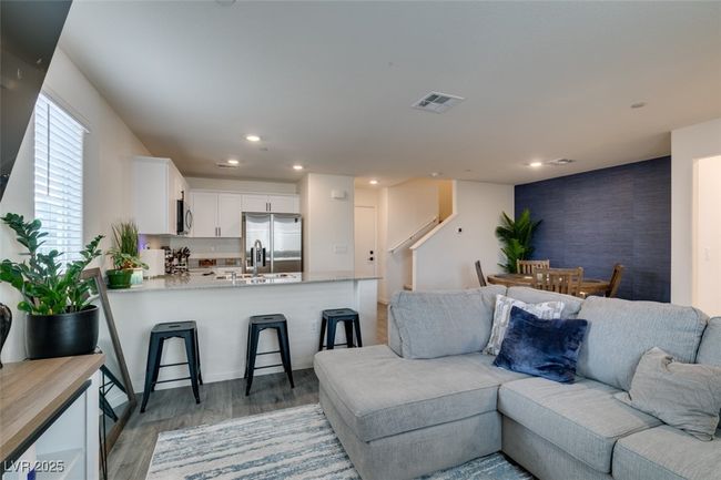 Living room with stairway, recessed lighting, light wood finished floors, and visible vents | Image 12