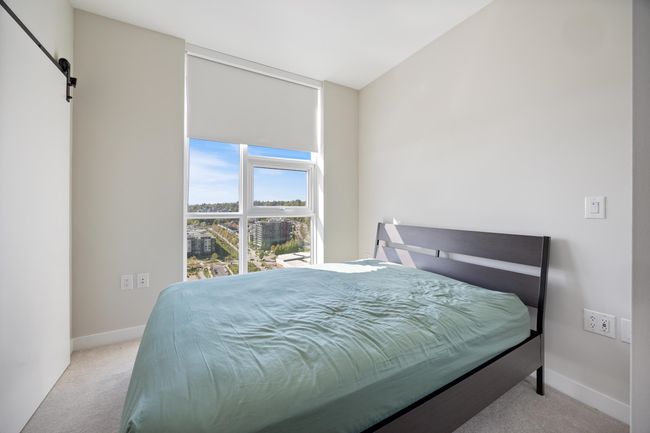 Bedroom with baseboards, a barn door, and carpet | Image 13