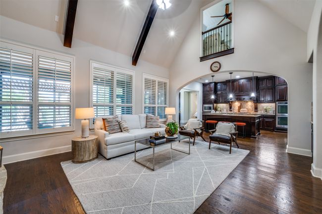 A wall of windows floods the space with natural light, while upgrades like plantation shutters and hand-scraped wood floors extend throughout. A charming Juliette balcony from the upstairs game room adds a unique touch and overlooks the main living area. | Image 16