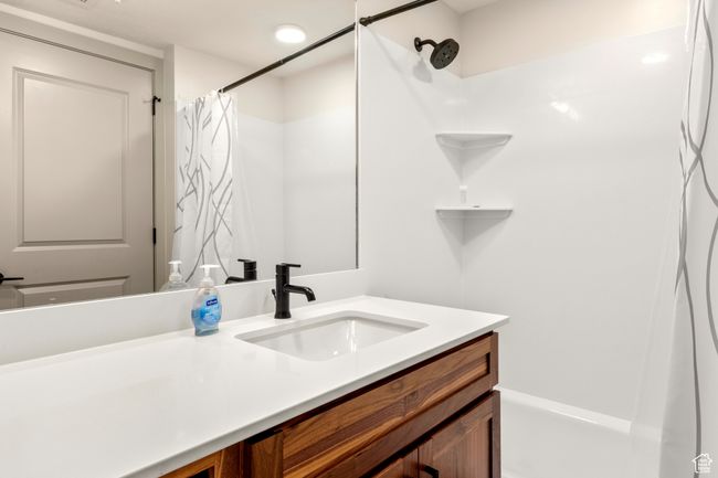 Bathroom featuring vanity and curtained shower | Image 33