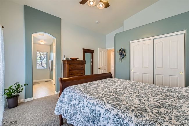 View of the Primary bedroom showing the entry into the primary bath suite, entryway door and closet doors. | Image 13