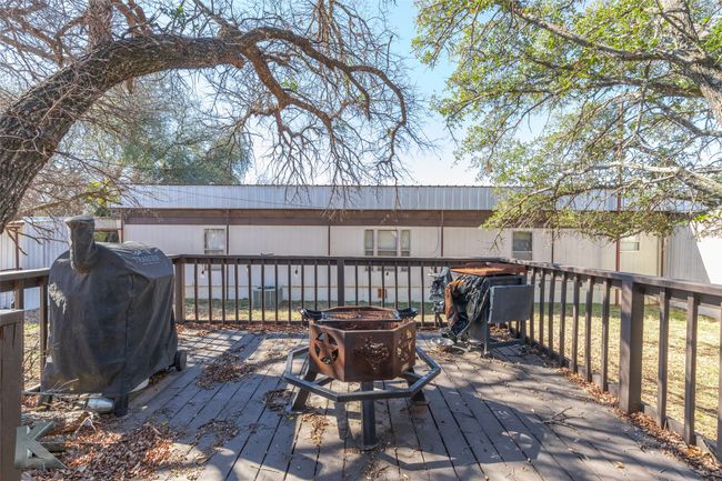 Wooden terrace featuring area for grilling and a fire pit | Image 8