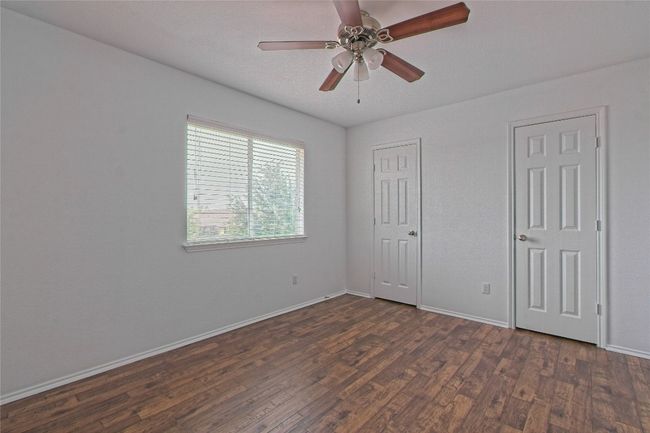 Unfurnished bedroom with dark wood finished floors and a ceiling fan | Image 26