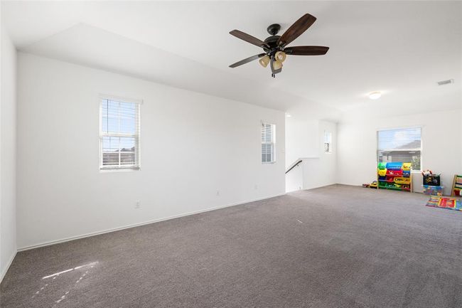 Empty room featuring plenty of natural light, carpet flooring, and ceiling fan | Image 24