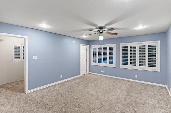 Carpeted spare room featuring a ceiling fan and baseboards | Image 24