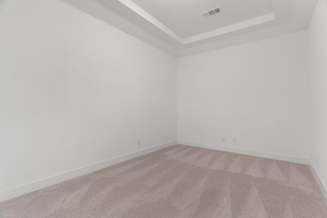 Empty room featuring light colored carpet, a tray ceiling, and baseboards | Image 19