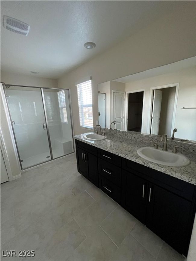Bathroom with a shower stall, double vanity, and tile patterned flooring | Image 14