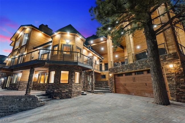Contemporary home with a balcony, stone siding, an attached garage, and decorative driveway | Image 4