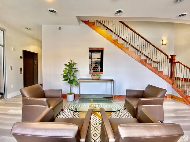 Living area with elevator, visible vents, and wood finished floors | Image 5