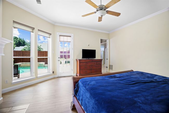 Bedroom featuring crown molding, wood finished floors, access to outside, and a ceiling fan | Image 16