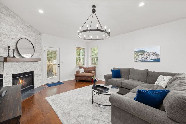 Living area with a chandelier, a fireplace, dark wood finished floors, and recessed lighting | Image 17