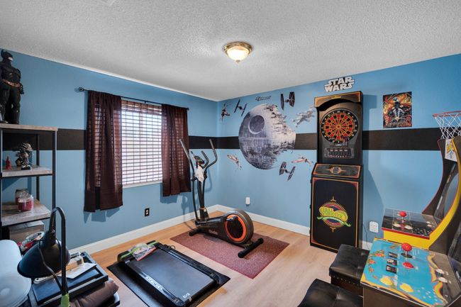 Exercise area featuring a textured ceiling and wood finished floors | Image 21