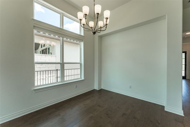 Spare room featuring plenty of natural light, a chandelier, and dark wood-style floors | Image 30