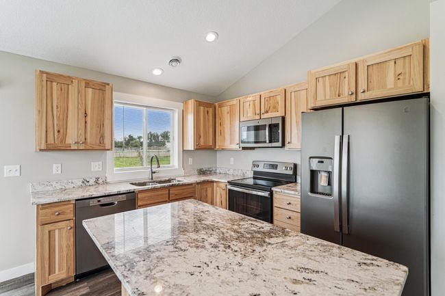 Kitchen features vaulted ceilings, birch cabinets, granite countertops, center island, S.S. appliances, and LVP flooring. | Image 10