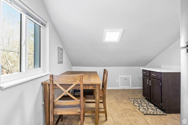 Dining space with light tile patterned floors, baseboards, and lofted ceiling | Image 17