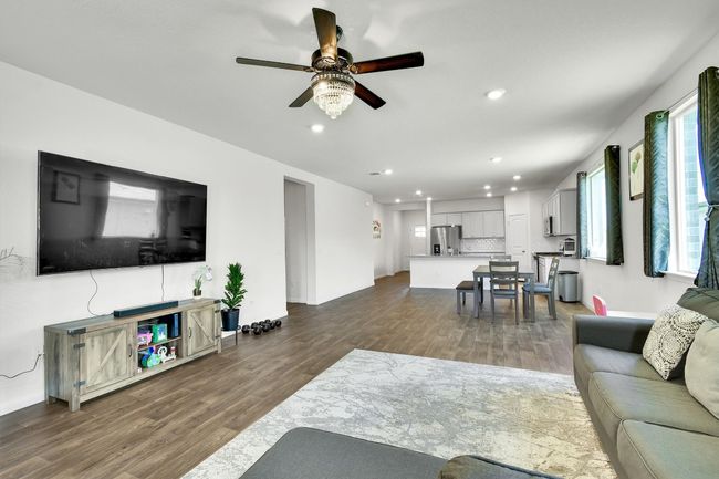 Living area with recessed lighting, ceiling fan, dark wood-type flooring, and baseboards | Image 14