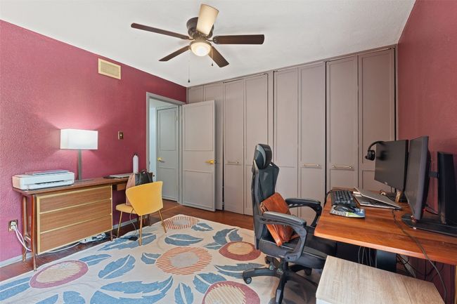 Home office with a ceiling fan, visible vents, and wood finished floors | Image 27