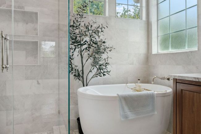 Enjoy relaxing in the free-standing soaking tub, situated under corner windows. | Image 25