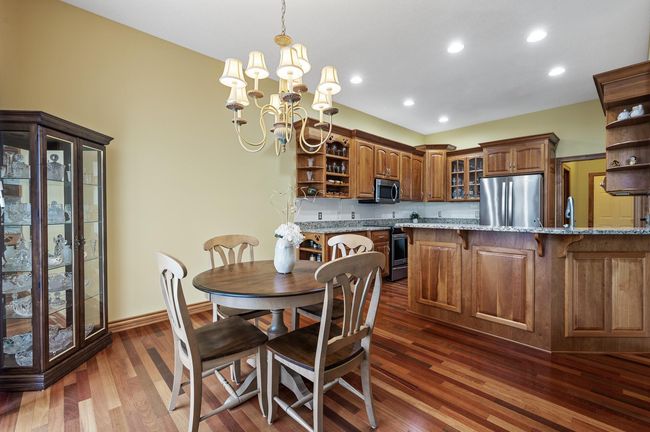 Beautiful natural wood floors & custom cherry cabinetry provide a warm rich ambiance to the casual dining and custom kitchen. | Image 9