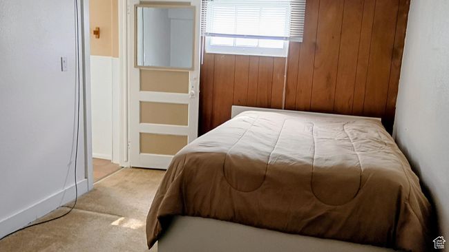 Carpeted bedroom with wood walls | Image 44