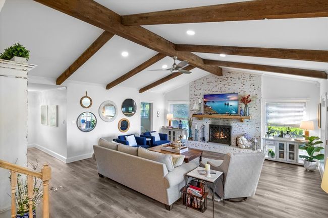 Living room with wood finished floors, ceiling fan, recessed lighting, and a brick fireplace | Image 9