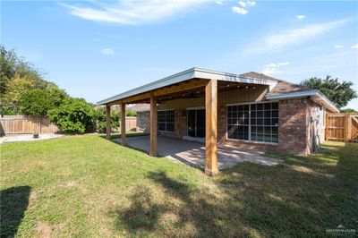 Rear view of property featuring ceiling fan, a yard, and a patio | Image 3