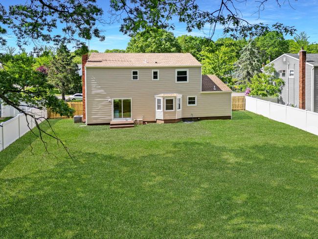 Rear view of property featuring cooling unit and entry steps | Image 37