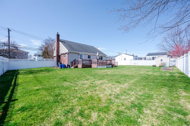 View of yard featuring an outbuilding, a storage unit, a fenced backyard, and a wooden deck | Image 20