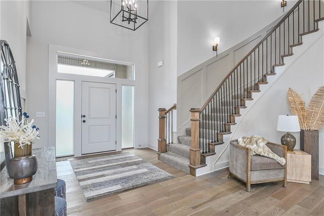 Foyer featuring an inviting chandelier, wood-type flooring, and a towering ceiling | Image 4