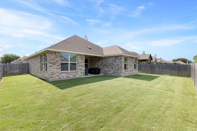 Back of house featuring a fenced backyard, brick siding, a shingled roof, and a chimney | Image 31