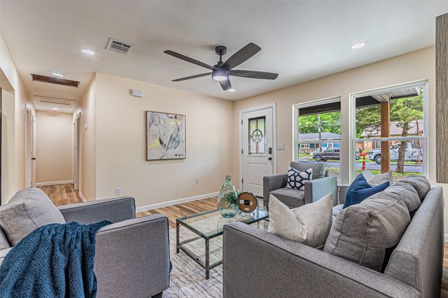Living area featuring light wood finished floors, baseboards, visible vents, recessed lighting, and a ceiling fan | Image 7