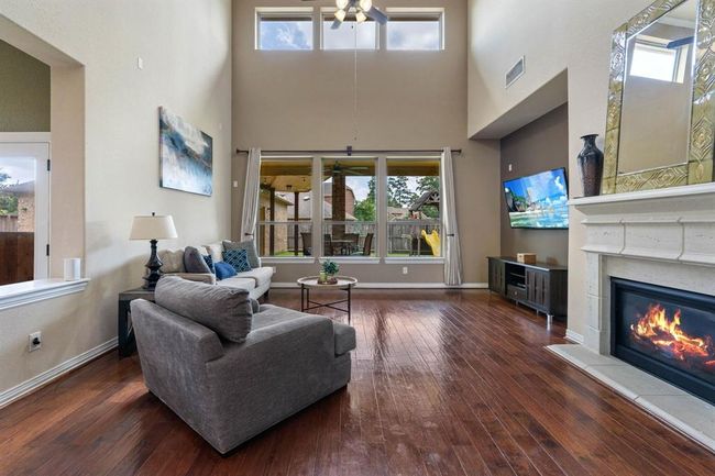 Walls of windows flood the spacious living room with natural sunlight. | Image 10