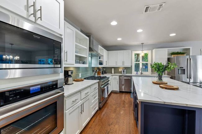 Kitchen with open shelves, appliances with stainless steel finishes | Image 11