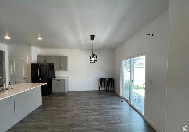 Kitchen with gray cabinetry, freestanding refrigerator, dark wood-type flooring, light countertops, and recessed lighting | Image 13