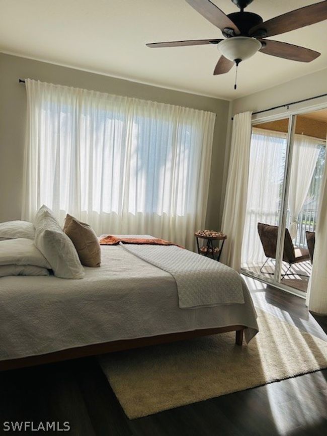 Bedroom featuring ceiling fan, access to exterior, multiple windows, and hardwood / wood-style floors | Image 16