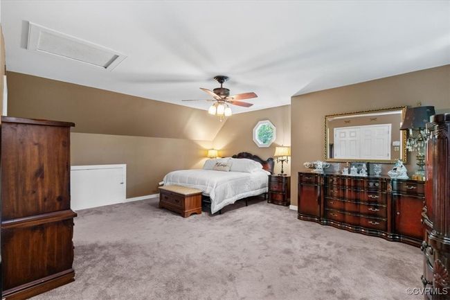 Carpeted bedroom with attic access, vaulted ceiling, a ceiling fan, and baseboards | Image 29