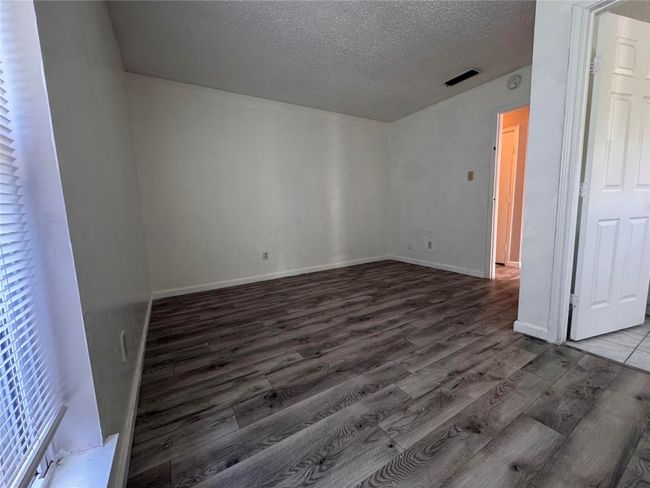 Unfurnished room featuring wood finished floors and a textured ceiling | Image 16