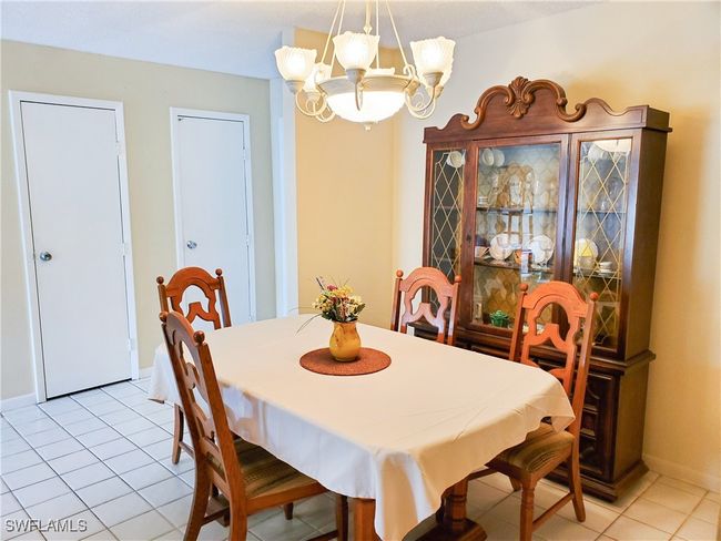 Dining space featuring a notable chandelier and light tile patterned floors | Image 10