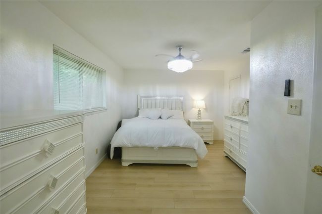 Bedroom with light wood-type flooring and ceiling fan | Image 8