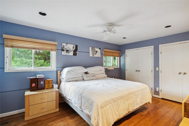 Bedroom featuring multiple closets, dark wood-style floors, and a ceiling fan | Image 9
