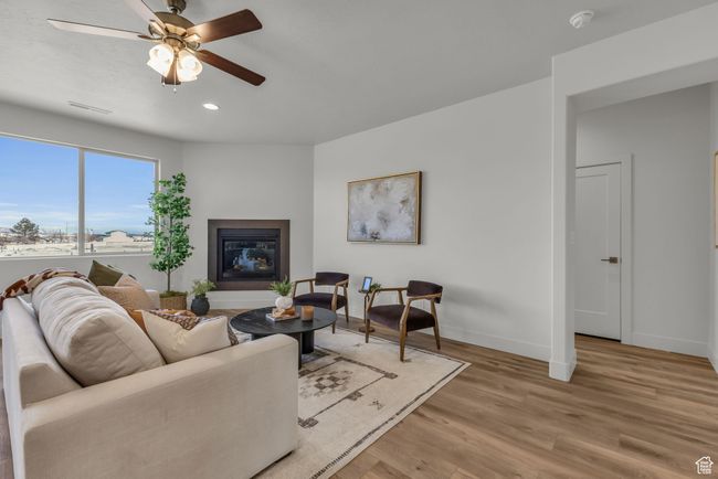 Living room with ceiling fan and light wood-type flooring | Image 7