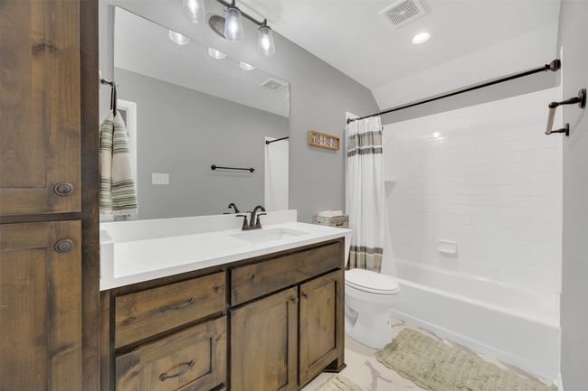 Bathroom featuring visible vents, vanity, toilet, and shower / tub combo with curtain | Image 25