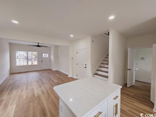 Kitchen with open floor plan, light countertops, a kitchen island, and white cabinetry | Image 27